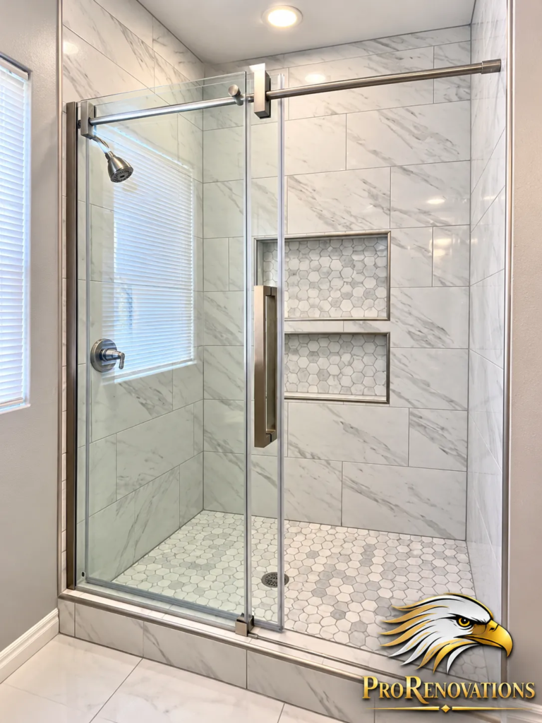 Bathroom with a marble-look tile shower, frameless sliding glass door and hexagon floor tile